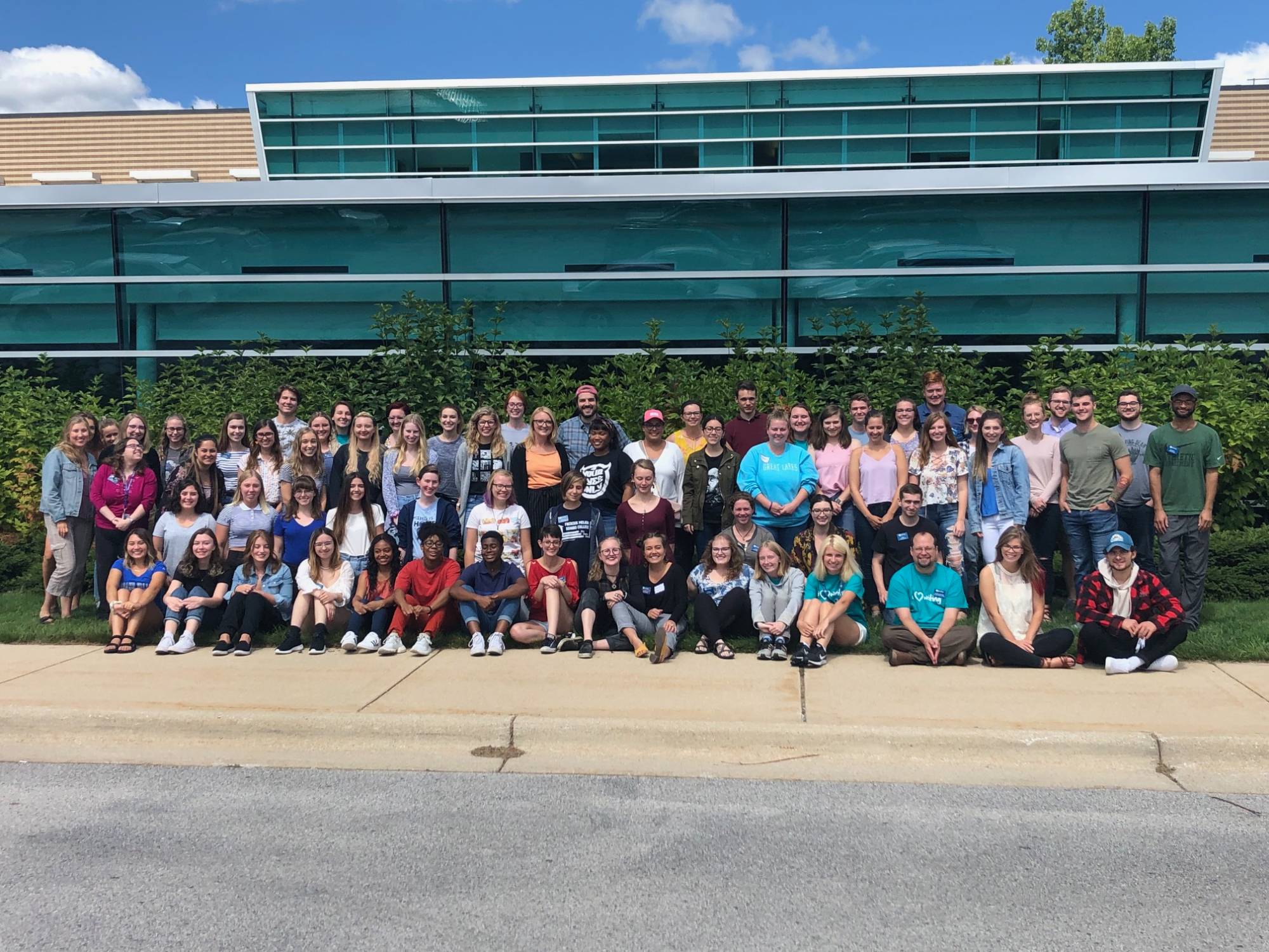 Full staff photo in front of lake ontario hall